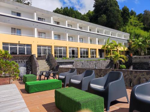 a row of chairs and tables in front of a building at Vista do Vale - Hotel in Furnas