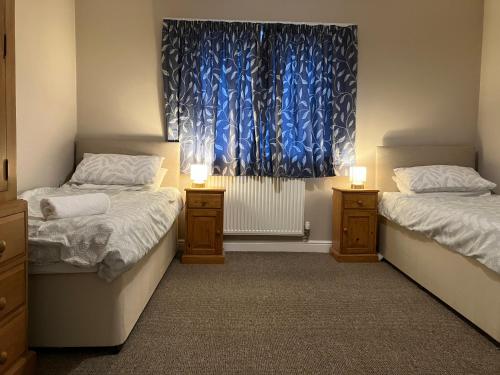 two twin beds in a room with a window at Cosy home near hospital in Carlisle