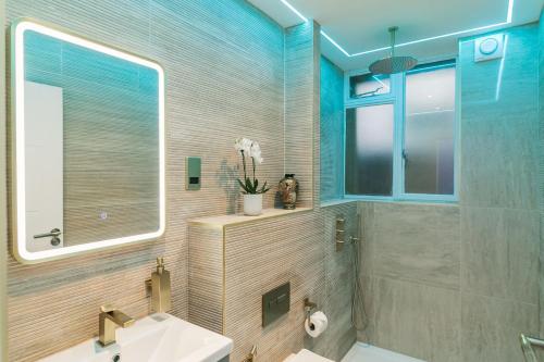 bagno con lavandino e doccia con specchio di WelcomeStay Fitzrovia Two Bed Apartments - Sleep in Opulent Luxury a Londra
