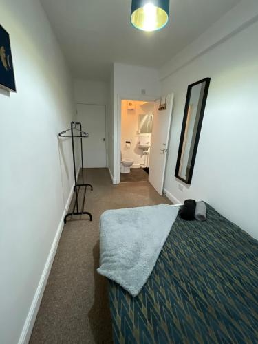 - une chambre avec un lit et une salle de bains avec un miroir dans l'établissement Spacious sofa bed lounge area with ensuite bedroom, à Wednesbury