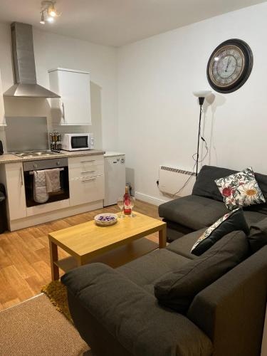 ウェンズベリーにあるSpacious sofa bed lounge area with ensuite bedroomのリビングルーム(ソファ、コーヒーテーブル付)