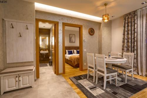 Cette chambre comprend un lit, une table et des chaises. dans l'établissement Kalman SPA&GYM, à Zlatibor
