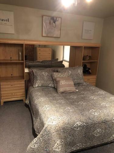 a bedroom with a bed and some wooden cabinets at Cuddys Place in Pittsburgh