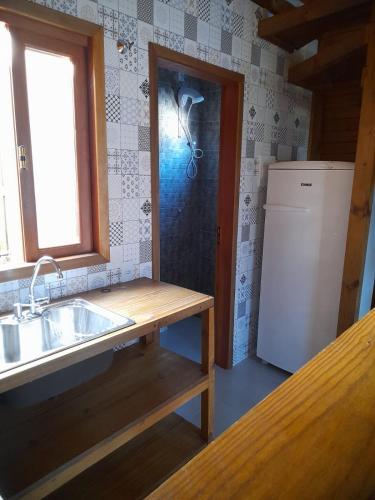 a kitchen with a sink and a refrigerator at Residencial Aracuã Praia Brava in Itajaí