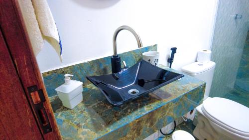 ein Badezimmer mit einem blauen Waschbecken und einem WC in der Unterkunft Casa no Caravaggio ao lado da cervejaria 3 Santas in Santa Teresa