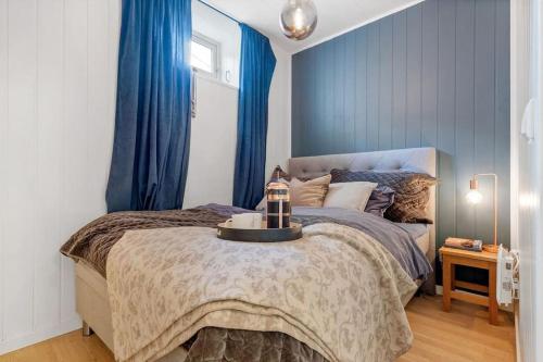 a bedroom with a bed with blue walls and blue curtains at Charming, Central, Coffee Machine in Ålesund