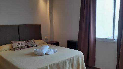 a bedroom with a bed with towels on it at Hotel Firenze in Necochea