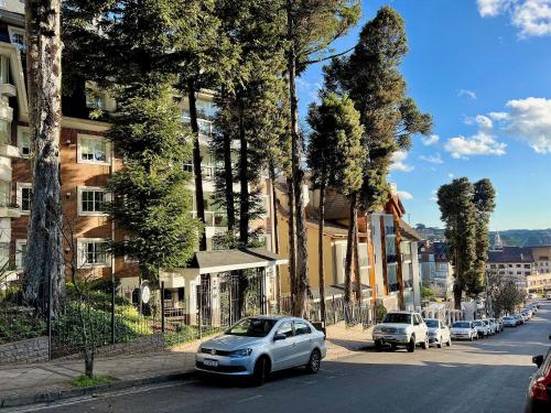 un coche blanco estacionado al lado de una calle en Apartamentos Condado Homelland CENTRO by Achei Gramado, en Gramado