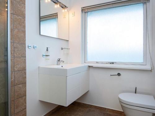 baño blanco con lavabo y ventana en Holiday home Knebel LIX, en Knebel