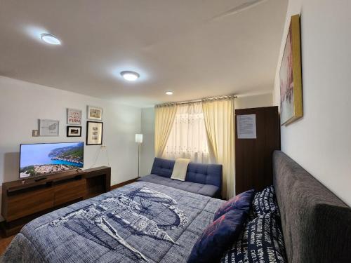 a bedroom with a bed and a flat screen tv at Fresnos 891 in Huancayo