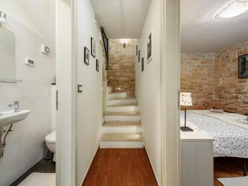 una escalera que conduce a un baño con lavabo y bañera en Casa Antignana, en Tinjan