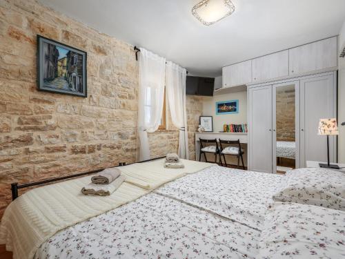 a bedroom with a bed and a brick wall at Casa Antignana in Tinjan