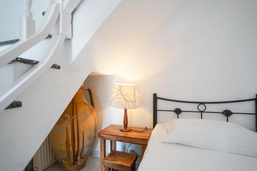 a bedroom with a bed and a table with a lamp at Fira Central Apartments with Veranda in Fira