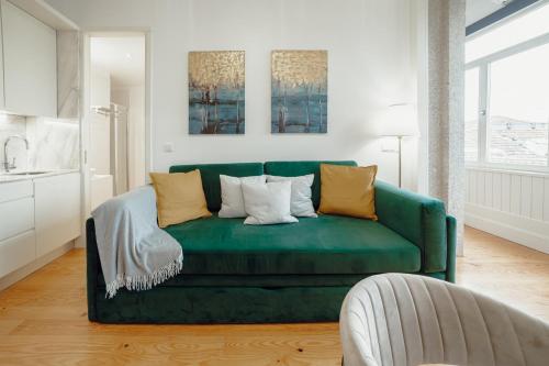- un canapé vert avec des oreillers dans le salon dans l'établissement Downtown Premium Apartment by Vacationy, à Porto