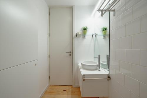 La salle de bains blanche est pourvue d'un lavabo et d'une douche. dans l'établissement Downtown Premium Apartment by Vacationy, à Porto