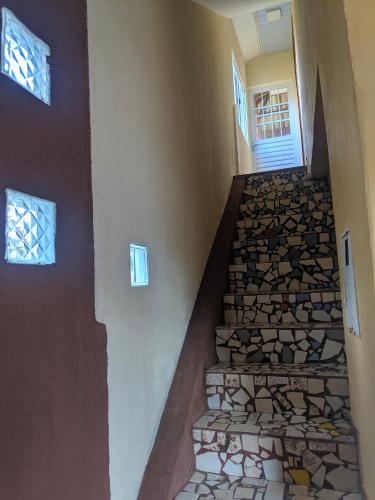 a stone staircase in a home with a stone wall at Sobrado da Vila, 1km Centro, ideal Trabalho e Passeio in Morretes