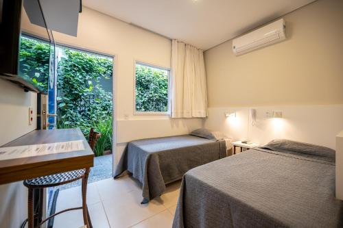 a hotel room with two beds and a window at K2 Residence in Campinas