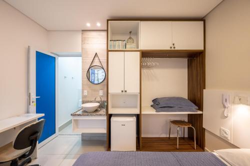 a small bathroom with a sink and a desk at K2 Residence in Campinas