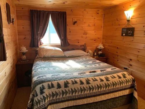 1 dormitorio con 1 cama en una cabaña de madera en Middle Pond Cabin- Direct ATV & Snowmobile Access, en Pittsburg