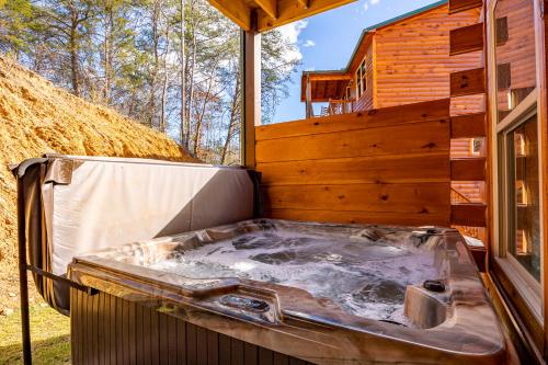 a hot tub in the back of a house at 5Bd5B Escape Cabin with 2 HotTubs, Thtr &Game Rm,1mi to the Parkway! 4mi to Dollywood - Spring Deal in Pigeon Forge