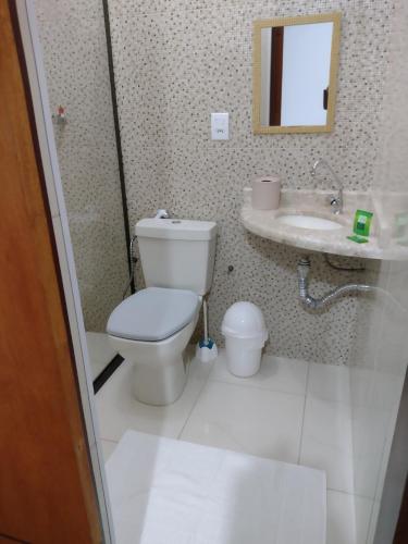 a bathroom with a toilet and a sink at Alvorada Guest House in Caxambu