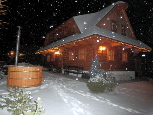 a log cabin in the snow at night at Liptovská Drevenica in Liptovský Mikuláš