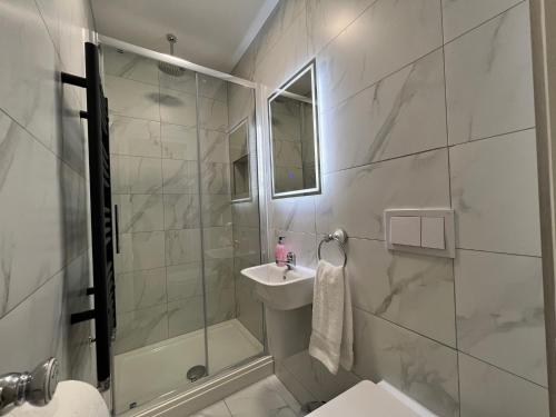 a bathroom with a shower and a sink and a mirror at Winckley Square Residences in Preston