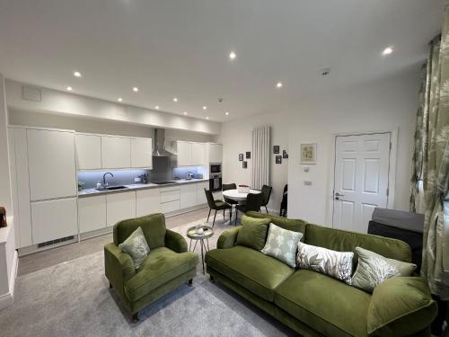 a living room with a green couch and a table at Winckley Square Residences in Preston