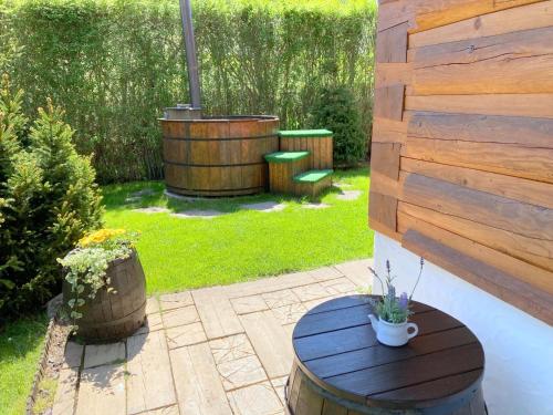 a patio with a barrel table and a wooden wall at Liptovská Drevenica in Liptovský Mikuláš