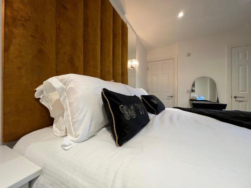 a bedroom with a white bed with black and white pillows at Winckley Square Residences in Preston
