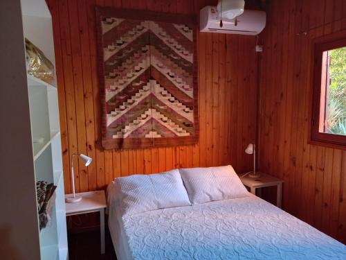 a bedroom with a bed and a quilt on the wall at Maneki in La Paloma