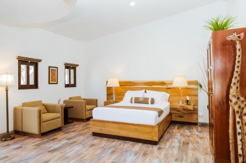 a hotel room with a bed and two chairs at Casa Emiliana in Valle de Guadalupe