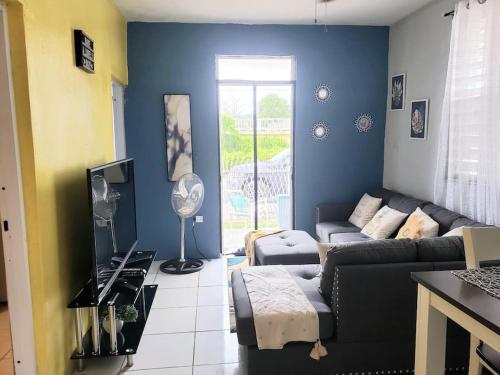 a living room with a couch and a tv at Casa Amalia Beach House in Aguada