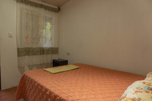 a bedroom with a bed with a yellow blanket on it at Posada Woochooch in San Juan La Laguna
