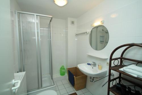 a white bathroom with a shower and a sink at App Seeblick in ruhiger Lage in Seedorf in Seedorf