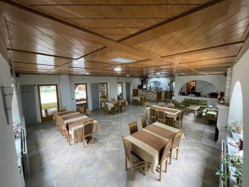 a dining room with wooden ceilings and tables and chairs at Perroi Shqiptar in Deçan
