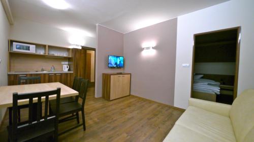 a kitchen and living room with a table and a couch at Riverside in Demanovska Dolina
