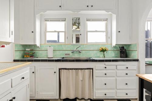 uma cozinha com armários brancos e um lavatório em Visit the Beach from a Historic Downtown Apartment - NRP21-00092 em Long Beach