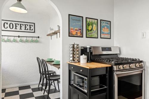 a kitchen with a stove and a table with chairs at Visit the Beach from a Historic Downtown Apartment - NRP21-00092 in Long Beach