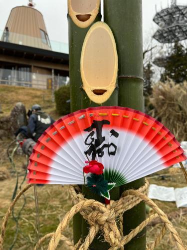 a red and white plate on a pole at 体験型古民家宿 旅ノ舎 in Nissaka