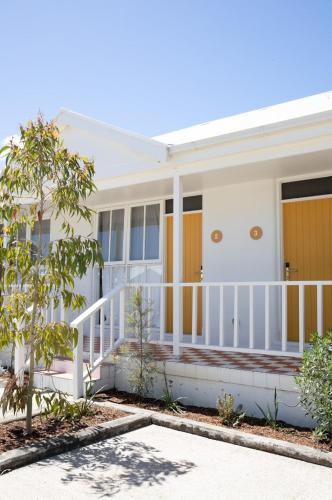 a white house with a white railing at Sunnymead Hotel in Aireys Inlet