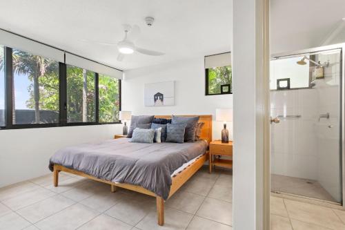 a bedroom with a bed and a shower at Seapoint Unit 14 32 Victoria Tce Kings Beach in Caloundra
