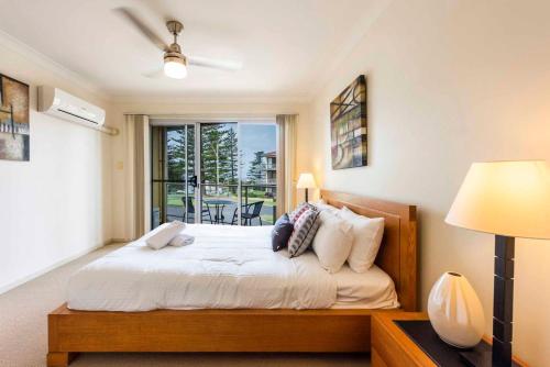 a bedroom with a bed and a window at Seaspray 5 in Yamba