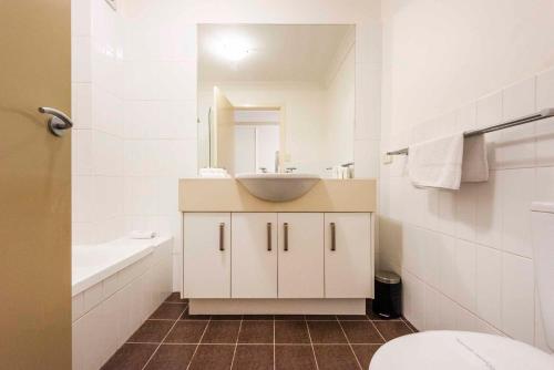 a white bathroom with a sink and a toilet at Seaspray 5 in Yamba