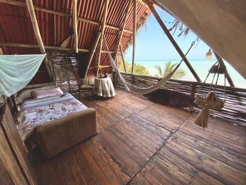 una habitación con una cama y una hamaca en un barco en Frente al Mar, en Dibulla