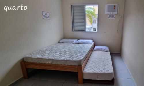 2 camas individuais num quarto com uma janela em Apartamento Encantador Ubatuba Praia Grande em Ubatuba
