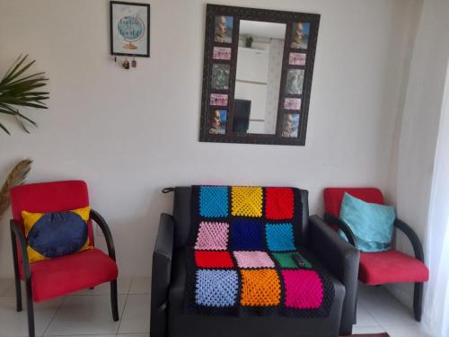 a room with two chairs and a colorful blanket at duplex em Imbé centro in Imbé