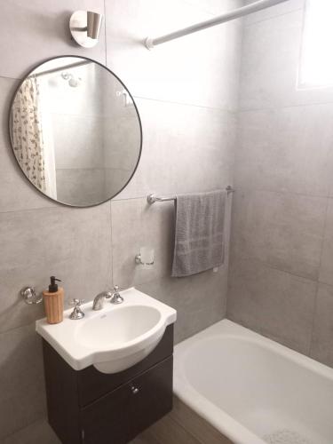La salle de bains est pourvue d'un lavabo, d'un miroir et d'une baignoire. dans l'établissement Cómodo departamento zona casino, à Mar del Plata