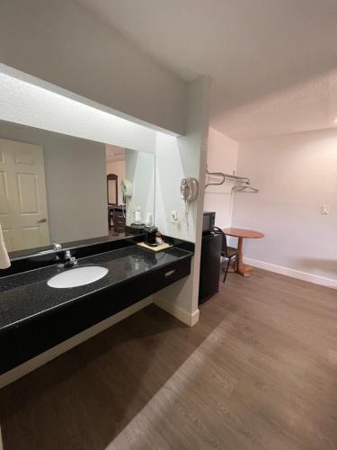 baño con lavabo y espejo grande en Western Inn en West Columbia