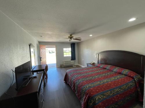 1 dormitorio con cama, tocador y espejo en Western Inn en West Columbia